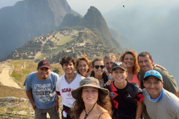 Group of travelers at Machu Picchu overlooking ancient ruins